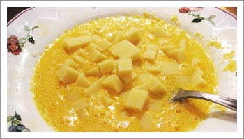 Taglia a dadini l'Emmental e grattugia 

il Parmigiano Reggiano. Sbatti le uova in un piatto fondo e aggiungici i formaggi appena preparati. 